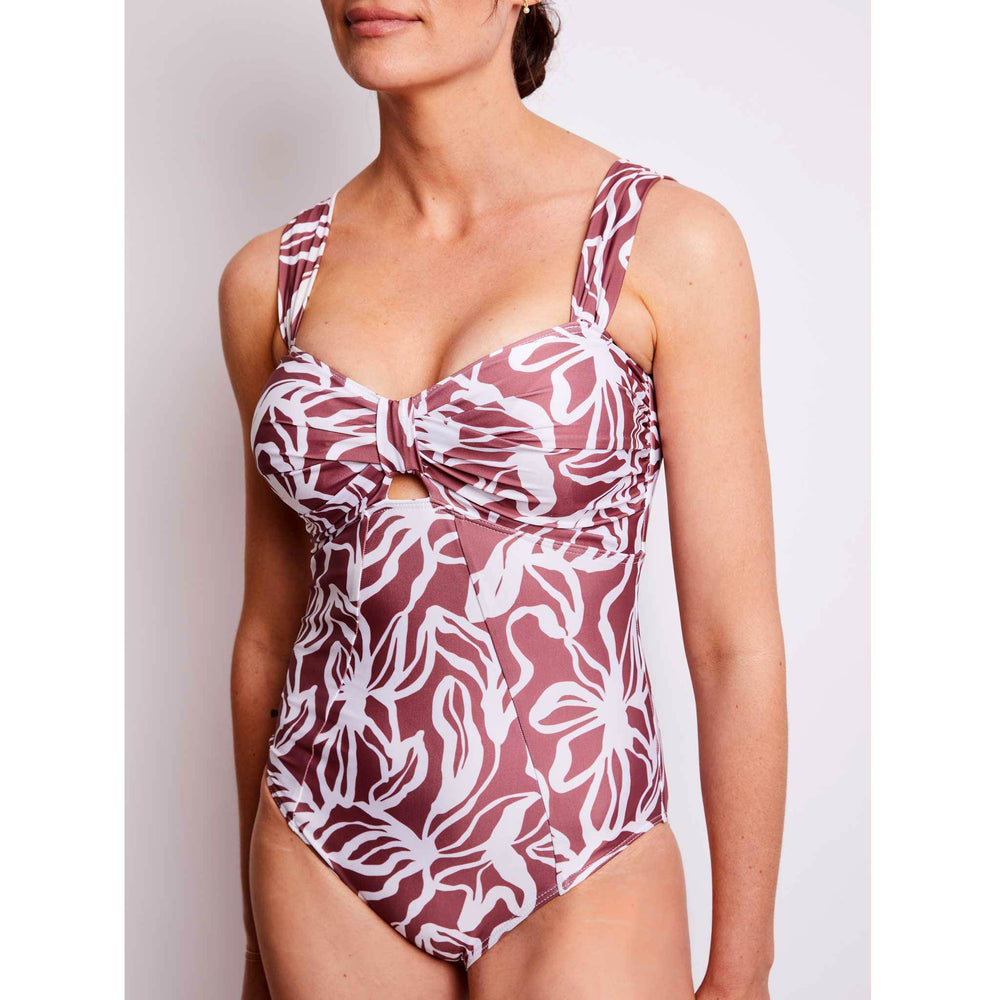 Woman wearing a supportive geometric floral white and brown swimsuit